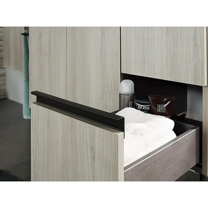 Riva Structure Waschtischunterschrank - 89,5 x 46 x 84,5 cm, Silbergrau, Matt - Ein offener, grauer Schubladenschrank mit Pflegeprodukten und einem weißen Handtuch im Badezimmer.