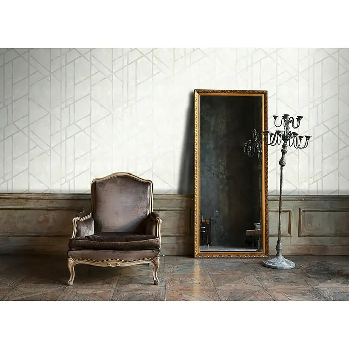 A.S. Création Metropolitan Stories Vliestapete Geometrie - Weiß/Grau, Grafisch, 10,05 x 0,53 m - Eine elegante Aufnahme von einem braunen Sessel neben einem goldenen Spiegel und einem Kerzenständer in einem stilvollen Interieur.