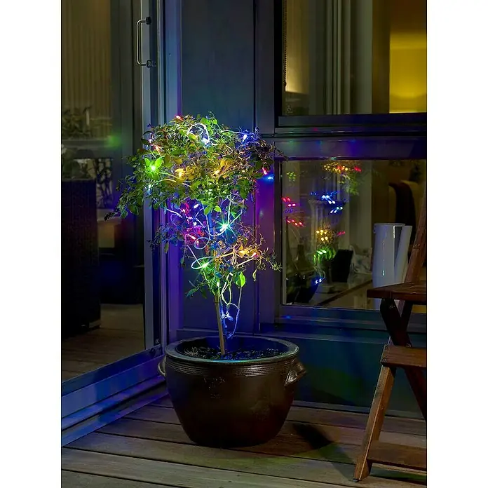 Konstsmide LED-Lichterkette - Außen, Lichtfarbe: Mehrfarbig, Anzahl Leuchtmittel: 80 Stk., Netzbetrieben, 12,64 m - Stimmungsvolle Dekoration: Ein kleiner Baum im Topf, geschmückt mit bunten Lichtern, die eine gemütliche Atmosphäre auf der Terrasse schaffen.