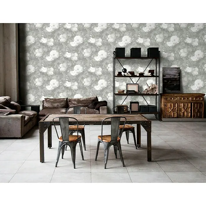 A.S. Création Metropolitan Stories Vliestapete Aquarell-Blume - Grau/Creme, Floral, 10,05 x 0,53 m - Einrichtung mit Esstisch aus Holz und Metallstühlen in einem Raum mit floral gemusterter Tapete und Regalen.
