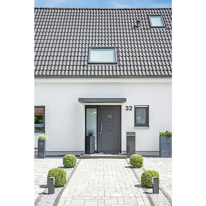 Gutta Rechteckvordach BS Standard 200 UP - 200 x 90 x 15,5 cm - Nahaufnahme eines modernen Hauses mit grauem Dach, weißen Wänden und gepflastertem Weg, der zum grauen Hauseingang führt.
