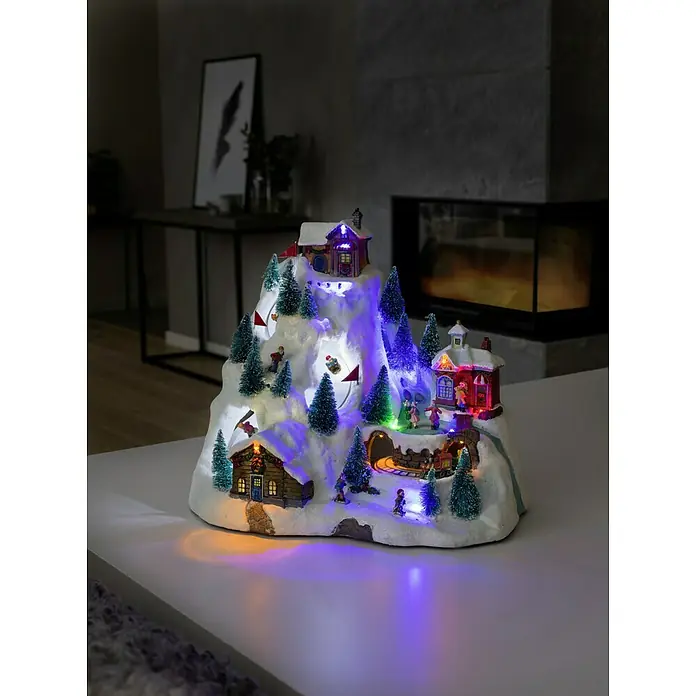 Konstsmide LED-Szenerie Skipiste - L x B x H: 31 x 20,5 x 27,5 cm, Bunt, Batteriebetrieben, LED - Festliche Winterdorf-Szene: Beleuchtetes Miniatur-Weihnachtsdorf mit beweglichen Elementen und warmem Licht, das eine gemütliche Atmosphäre schafft.