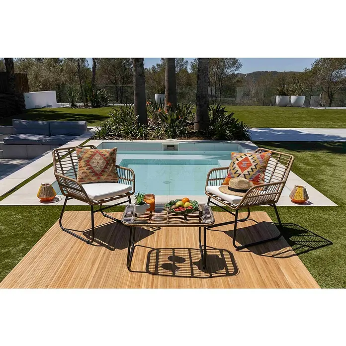 Conjunto de muebles Delfina - 3 pzs., Ratán sintético/Acero, Marrón - Acogedora escena al aire libre con dos sillas de ratán, una mesa con fruta y artículos decorativos junto a la piscina. Perfecto para relajarse al aire libre.
