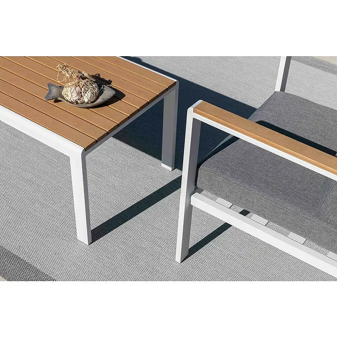 Sunfun Conjunto de muebles Selma - 4 pzs., Aluminio/Polywood, Blanco - Primer plano de una mesa de exterior con tablero de madera y estructura blanca, junto a una silla a juego con cojín gris.