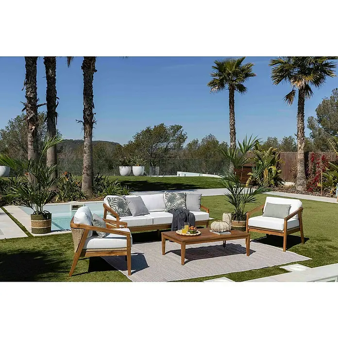 Sunfun Conjunto de muebles Anna - 4 pzs., Madera de acacia, Marrón - Conjunto de salón de exterior con estructuras de madera, cojines blancos y una mesa de centro a juego sobre una alfombra de exterior.