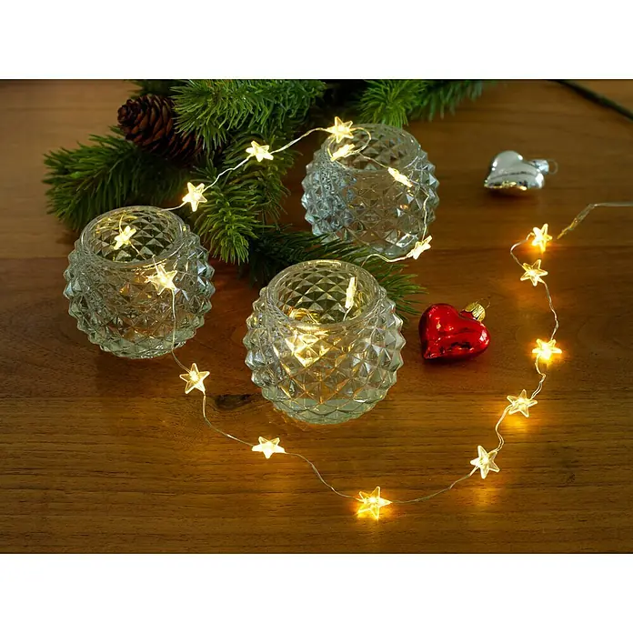 Konstsmide LED-Lichterkette Leuchtsterne - Innen, Lichtfarbe: Warmweiß, Anzahl Leuchtmittel: 20 Stk., Batteriebetrieben - Stimmungsvolles Arrangement mit drei verzierten Teelichthaltern, Sternenlichterkette, Tannenzweigen, Zapfen und Weihnachtsdeko auf Holzgrund.