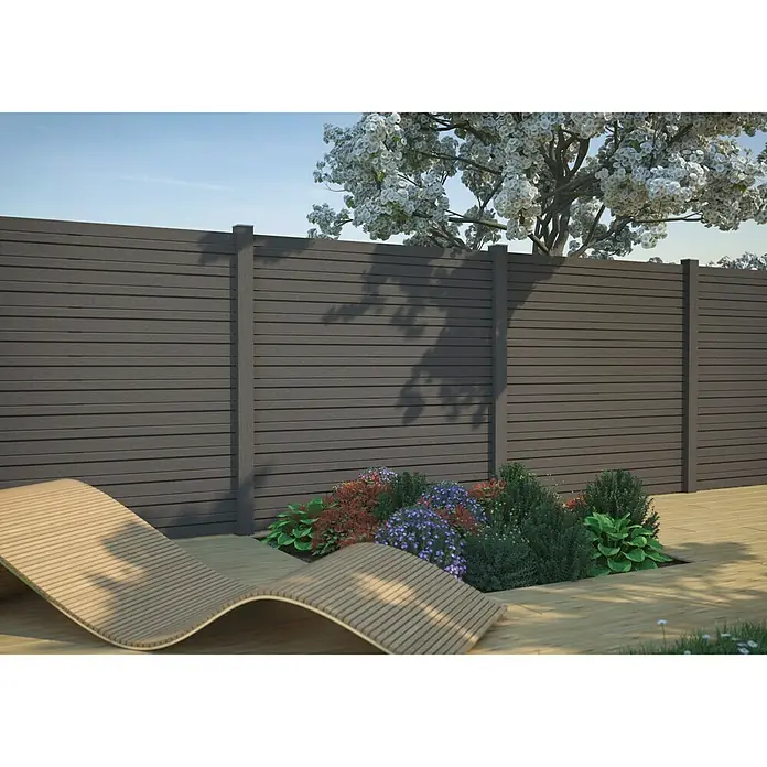 Kiehnholz Sichtschutzelement Design-Rhombus - B x H: 179 x 179 cm, Anthrazit - Das Bild zeigt einen modernen, grauen Holzzaun, der ein stilvolles Ambiente im Garten schafft. Eine Holzliege und blühende Pflanzen ergänzen das Bild.