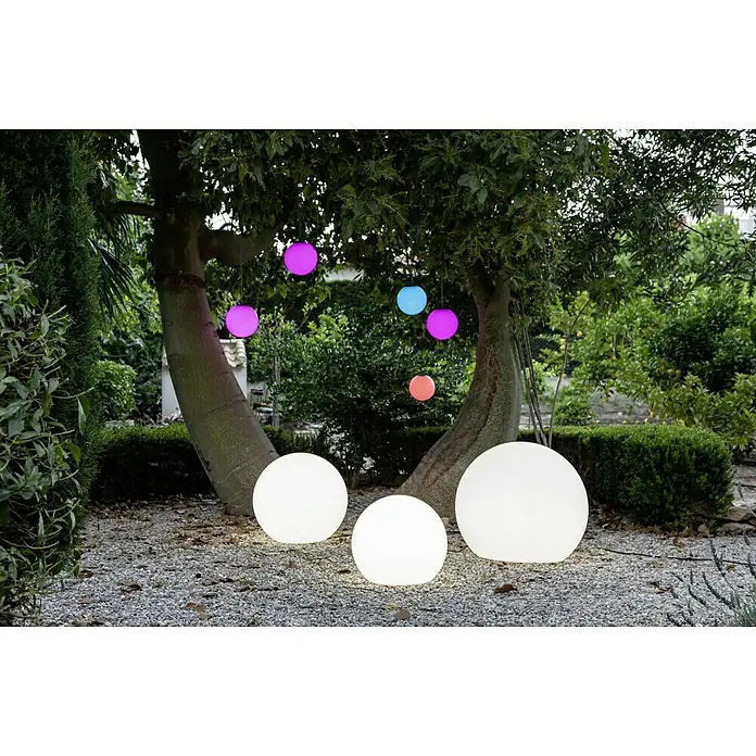 New Garden Design-Außenleuchte Buly 30 - Durchmesser: 30 cm, E27, IP65 - Leuchtende Outdoor-Dekoration mit weißen Kugelleuchten auf dem Boden und farbigen Hängeleuchten in den Bäumen für eine stimmungsvolle Atmosphäre.