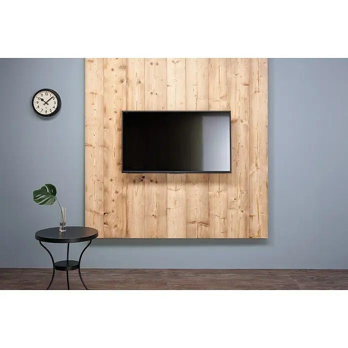 Massivholzbrett Tiroler Fichte - Fichte, 200 x 28,8 x 2,7 cm, Gehackt - Ein elegantes Interieur mit einem modernen Fernseher an einer Holzwand, ergänzt durch eine stilvolle Uhr und einen Beistelltisch mit Pflanze.