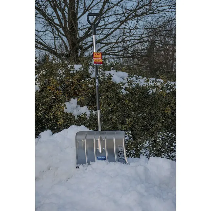 Freund Victoria Aluline Schneeschieber - Breite: 50 cm, Langstiel - Schneeschaufel der Marke Freund im Schnee. Die Schaufel hat einen roten Aufkleber am Stiel und einen silbernen Schaufelkopf.