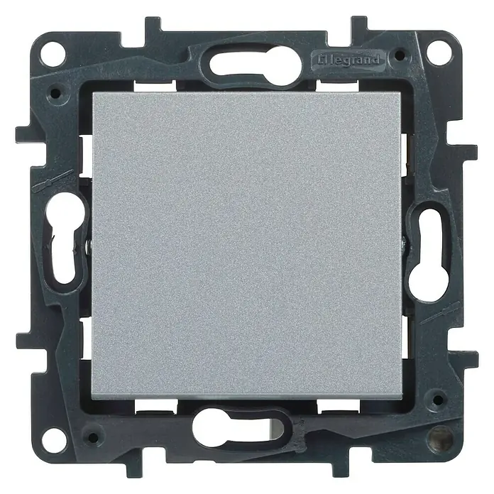 Legrand Niloé Step Cruzamiento - Aluminio, Instalar, IP44 - Primer plano de un interruptor de luz Legrand con un botón cuadrado plateado y un marco gris oscuro para montaje en pared.