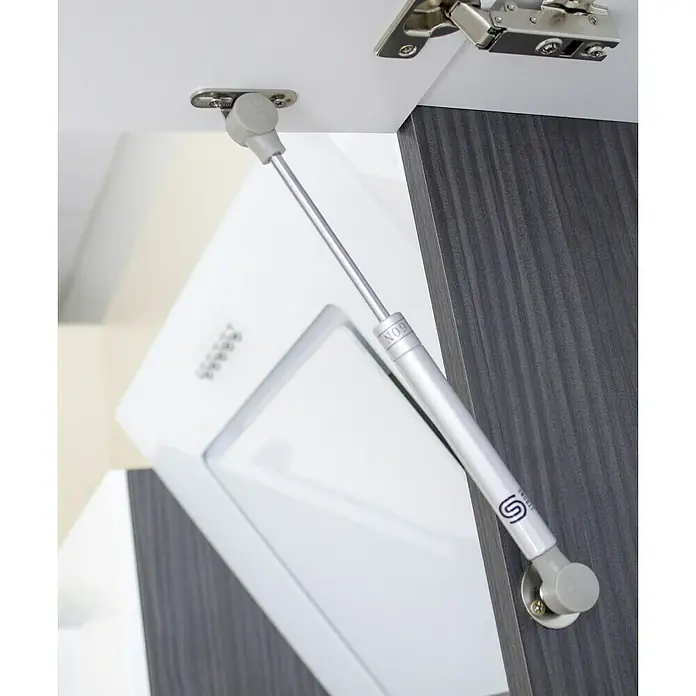 Respekta Premium Küchenzeile RP300ESCBO - Breite: 300 cm, Schwarz, Mit Elektrogeräten - Silberne Gasdruckfeder zur Unterstützung einer Schranktür, die an einer weißen Innenseite und einer grauen Außenseite befestigt ist.