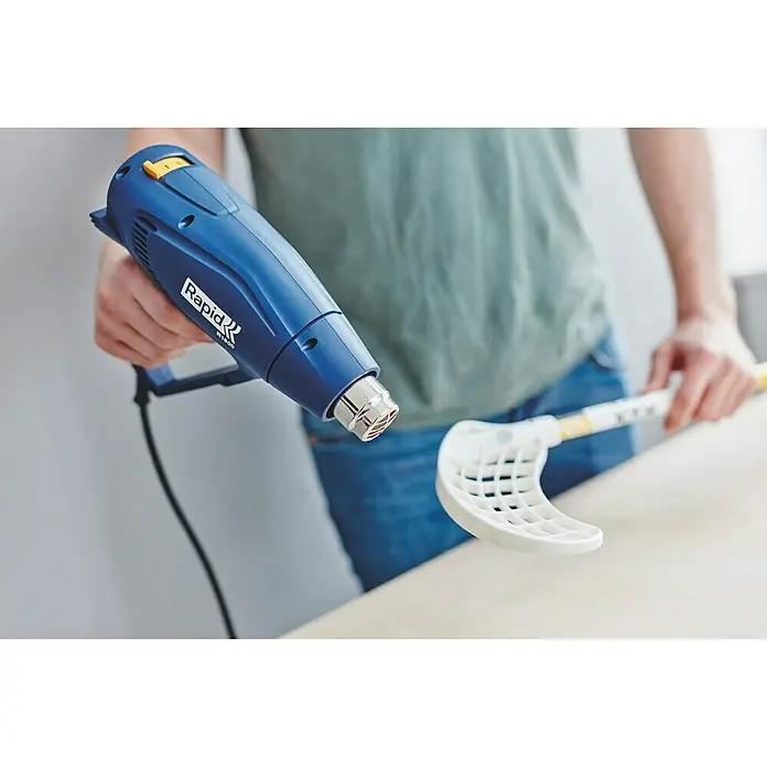 Rapid Heißluftgebläse R1800 - 1.800 W, Temperaturbereich: 300 °C - 550 °C - Mann verwendet eine blaue Rapid RT200 Heißluftpistole, um einen weißen Unihockey Schläger zu bearbeiten.
