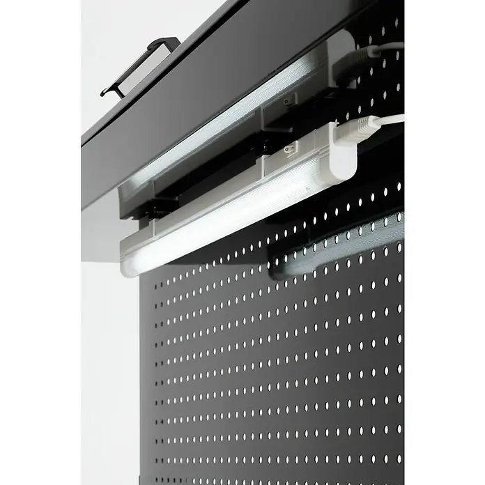Wisent Banco de trabajo - L x An: 114 x 61 cm, Altura de trabajo: 160 cm, Carga soportada: 140 kg, Negro - Primer plano de una luminaria LED montada debajo de un estante negro de tablero perforado. La lámpara proporciona una iluminación brillante y eficiente.