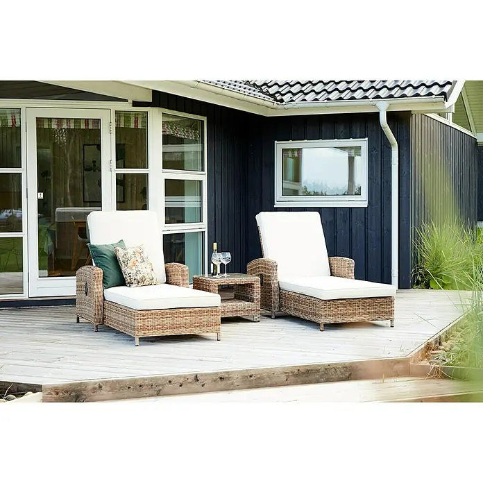 Tumbona de jardín Gotland - 83,5 x 206 x 26 cm, Arena, Acero, Respaldo regulable - Dos tumbonas de ratán con cojines blancos y una mesa auxiliar con vino y copas en una terraza de madera frente a una casa.