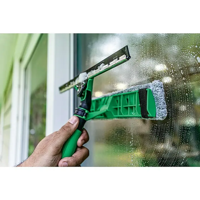 Unger Mikrofaser-Reinigungspad Visa Versa Pro - Breite Bezug: 35 cm, 100 % Polyacryl (Fasern) - Ein Fensterwischer mit grünem Griff und Schwammaufsatz reinigt eine verschmutzte Fensterscheibe mit Seifenlauge. Das Produkt sorgt für streifenfreie Sauberkeit.