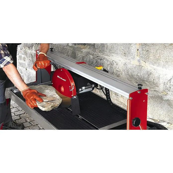 Einhell Diamant-Trennscheibe - Geeignet für: Steintrennmaschinen, Durchmesser Scheibe: 300 mm, Stärke Scheibe: 8 mm - Ein Mann mit Schutzhandschuhen bedient eine Einhell Fliesenschneidmaschine, um einen Stein zu schneiden.