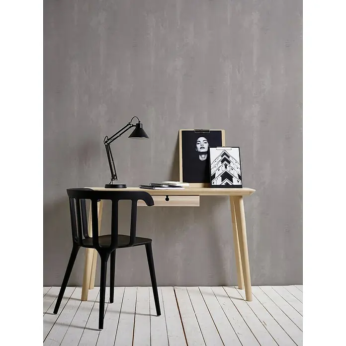 A.S. Création Neue Bude 2.0 ED II Vliestapete Concret - Taupe, Betonoptik, 10,05 x 0,53 m - Der elegante Schreibtisch mit der schwarzen Lampe, dem modernen Stuhl und den Bildern schafft eine stilvolle Arbeitsatmosphäre.