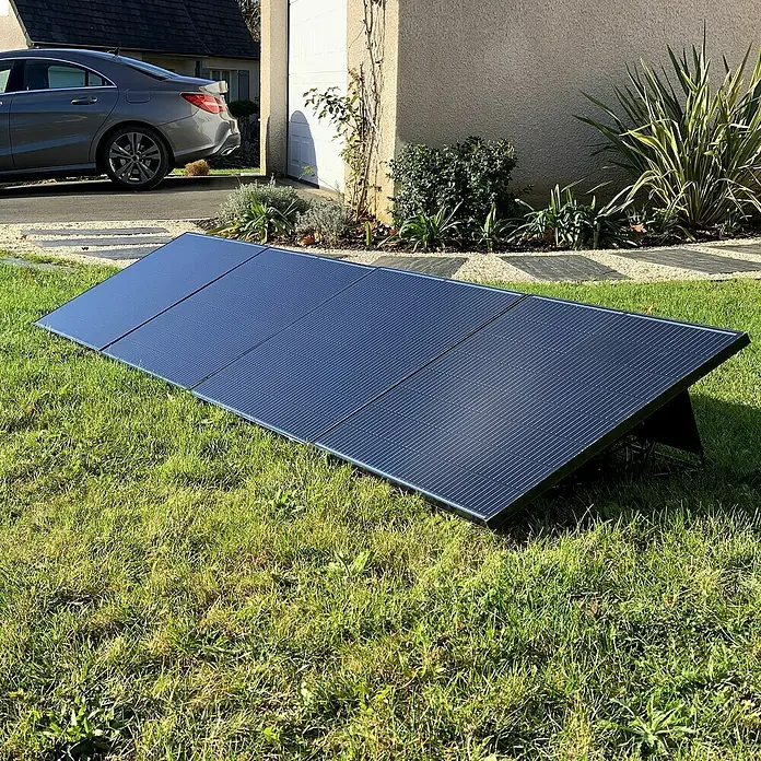 Avidsen Panel solar Soria - L x An x Al: 25 x 760 x 680 mm - Un sistema de paneles solares portátiles reposa sobre un césped verde, perfecto para la generación de energía ecológica al aire libre.