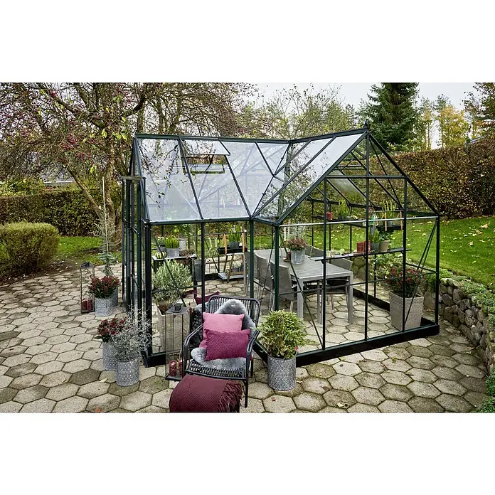 Halls Gewächshaus Garden Room - Außenmaß inkl. Dachüberstand (B x T): 389 x 390 cm, Farbe Gestell: Grün, Wandstärke: 3 mm - Geräumiges Gewächshaus mit Möbeln und Pflanzen auf einer gepflasterten Terrasse. Ideal für Gartenliebhaber, die Stil und Funktionalität suchen.