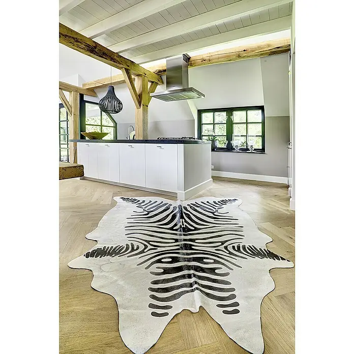 Esbeco Kuhfell - 100 % Echtfell, Zebra - Ein modernes Interieur mit einem auffälligen Zebra-Teppich im Vordergrund, der das helle Holzfußbodenmuster ergänzt.