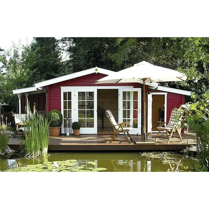 Weka Gartenhaus Weekendhaus 137 - Außenmaß inkl. Dachüberstand (B x T): 460 x 370 cm, Holz, Natur - Blick auf ein kleines, rot gestrichenes Gartenhaus am Ufer eines Teichs mit einer hölzernen Terrasse, die zum Entspannen einlädt.