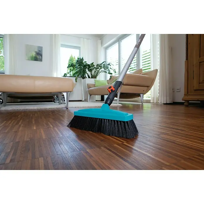 Gardena Combisystem Besen - Passend für: Gardena Combisystem Stiele - Eine Nahaufnahme eines Gardena Kehrbesens, der auf einem Holzboden steht, mit hellem Wohnzimmer im Hintergrund.