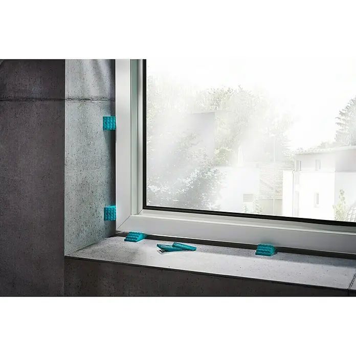 Wolfcraft Keile - 30 Stk. - Das Bild zeigt blaue Fensterkeile, die verwendet werden, um ein Fenster während der Installation zu stabilisieren.