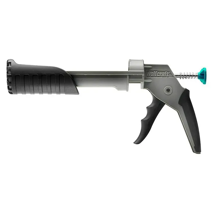 Wolfcraft Kartuschenpresse MG 211 ERGO - Passend für: 310 ml Kartuschen Ø 50 x 225 mm, Acryl - Abbildung einer Wolfcraft Auspresspistole für Kartuschen. Die Pistole ist grau mit schwarzen Griffen und einem türkisfarbenen Knopf.