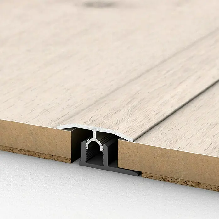 MyStyle MyArt Universalprofil 3in1 Misty Plains Oak - 1 m x 34 mm x 15 mm, Montageart: Stecken - Übergangsprofil für Bodenbeläge:  Ein Detailansicht eines T-förmigen Übergangsprofils aus Aluminium zwischen zwei Bodenbelägen.