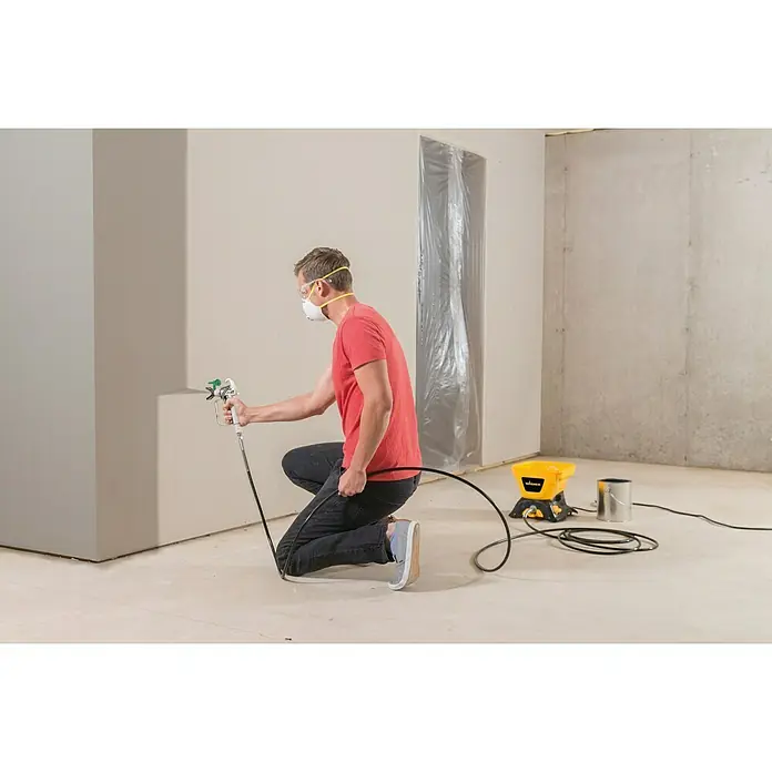 Wagner High Efficiency Airless Farbsprühsystem Control 150 M - 350 W, Förderleistung: 0,9 l/min - Mann lackiert Wand mit Airless Farbspritzgerät, gelb. Ideal für Projekte.