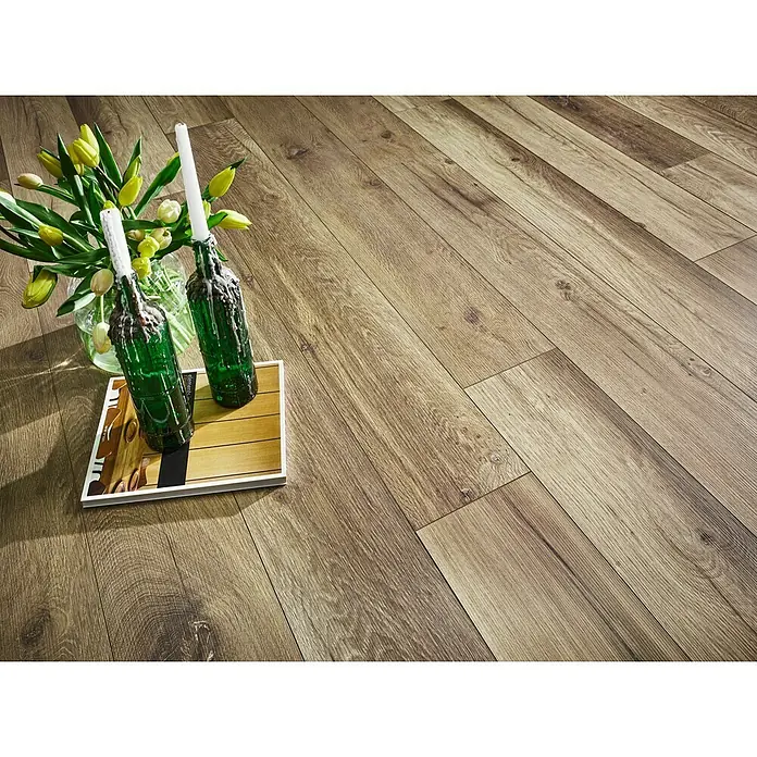 MyStyle MyArt Laminatmuster Wild West Oak - 200 x 195 x 12 mm, Landhausdiele - Einladende Ansicht von braunem Laminatboden, dekoriert mit Blumen, Kerzen und einer Zeitschrift für eine stilvolle Raumatmosphäre.