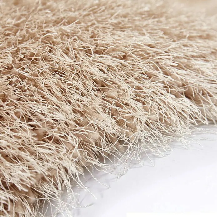 Kayoom Hochflorteppich Cosy - Champagner, 170 x 120 cm, 100 % Polyester - Nahaufnahme eines beigen Shaggy-Teppichs, der weich und luxuriös aussieht und eine warme Textur für jeden Raum bietet.