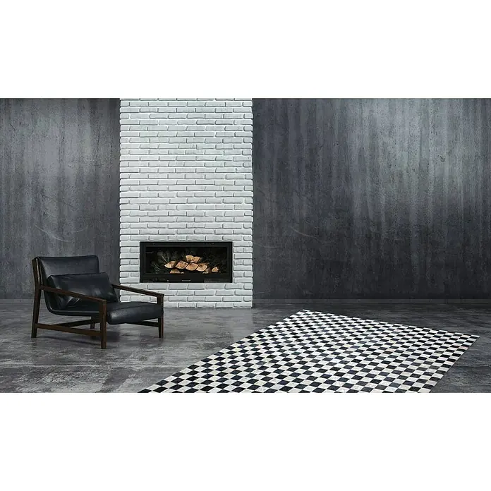 Kayoom Lederteppich Rocket - Anthrazit/Silber, 150 x 80 cm, 100 % Leder - Schwarzer Sessel vor einem Kamin und einem schwarz-weiß karierten Teppich. Ein modernes Interieur mit stilvollen Akzenten für ein gemütliches Zuhause.