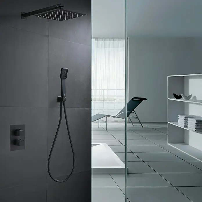 Imex Sistema de ducha empotrado Cies - Con grifo termostático, Negro - Conjunto de ducha oscuro con rociador y ducha de mano en pared gris, complementado con un diseño de baño moderno con tumbona y estantería.