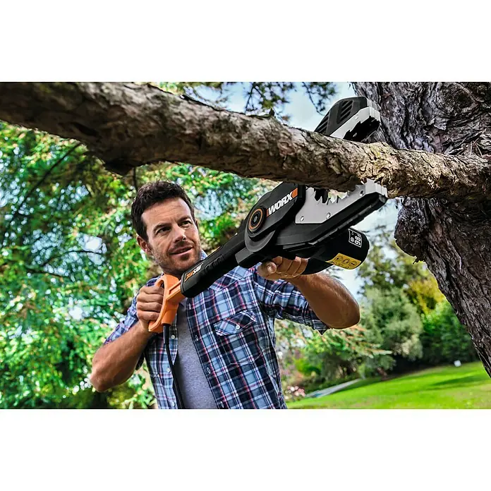 Worx PowerShare 20V Akku-Astsäge WG329E.9 - 20 V, Li-Ionen, Ohne Akku, Schwertlänge: 15 cm - Ein Mann benutzt eine WORX Akku-Kettensäge, um einen Ast im Garten zu schneiden. Das Gerät ist schwarz und orange.