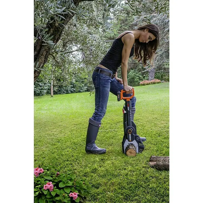 Worx PowerShare 20V Akku-Astsäge WG329E.9 - 20 V, Li-Ionen, Ohne Akku, Schwertlänge: 15 cm - Frau im Garten beim Sägen von Holz mit einer WORX-Kettensäge, die Komfort und Effizienz für Gartenarbeiten bietet.