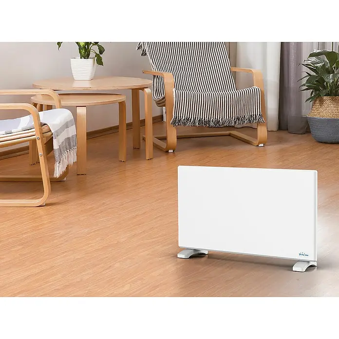 Purline Emisor térmico digital Panel S1500 - 1.500 W, Blanco, 8 x 70 x 40 cm - Un calentador Perel blanco está situado en un suelo de madera en una sala de estar, proporcionando calor y confort al espacio.