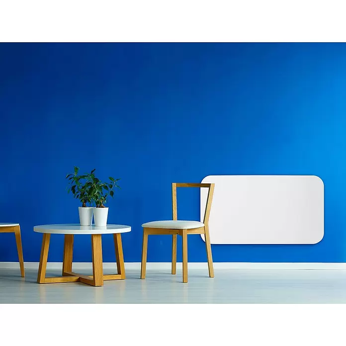 Purline Emisor térmico Ceramic AC1000 WiFi - 1.000 W, Blanco, 10 x 73 x 53 cm - Habitación moderna con una pared azul vibrante, una mesa redonda blanca, una silla de madera y un panel de pared rectangular blanco.