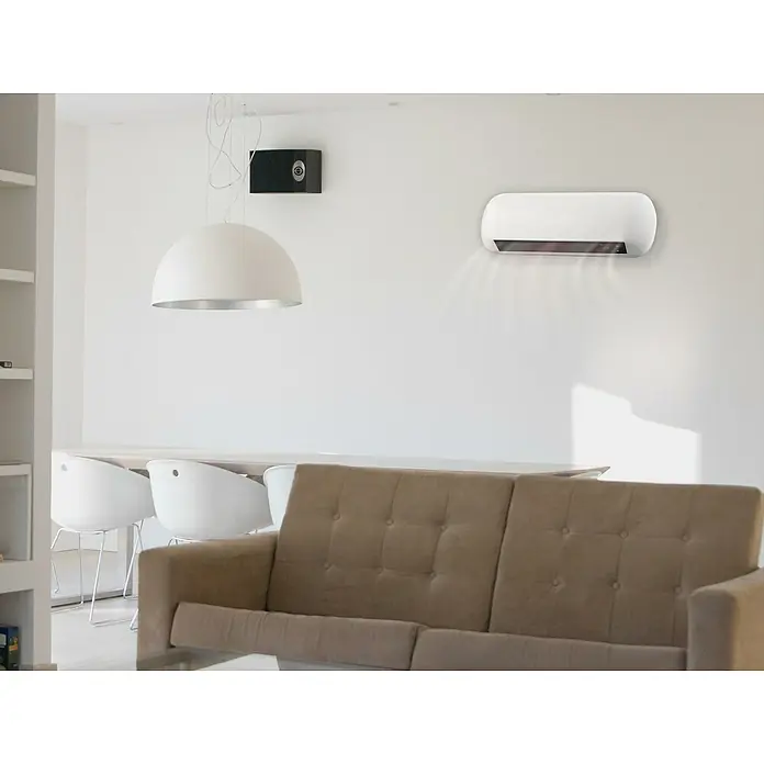 Purline Calefactor de aire Split HOTI M55 - 2.000 W, Blanco - Una sala de estar moderna con un elegante calentador blanco montado en la pared que emite calor. Dominan los colores claros y el diseño minimalista.