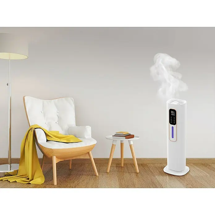 Purline Humidificador Hydro 20 - 20 x 22 x 70 cm, Blanco - Un humidificador blanco al lado de una mesa y un sillón, garantizando un clima interior agradable.