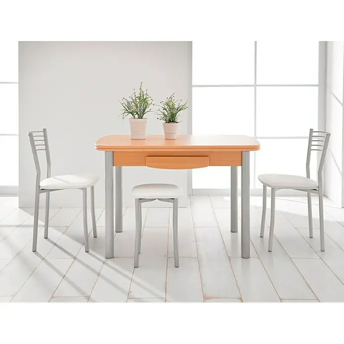 Silla Kopa - L x An x Al: 47 x 40 x 85 cm, Blanco - Luminoso conjunto de comedor con mesa de madera, sillas plateadas con asientos blancos y flores decorativas para un ambiente acogedor.
