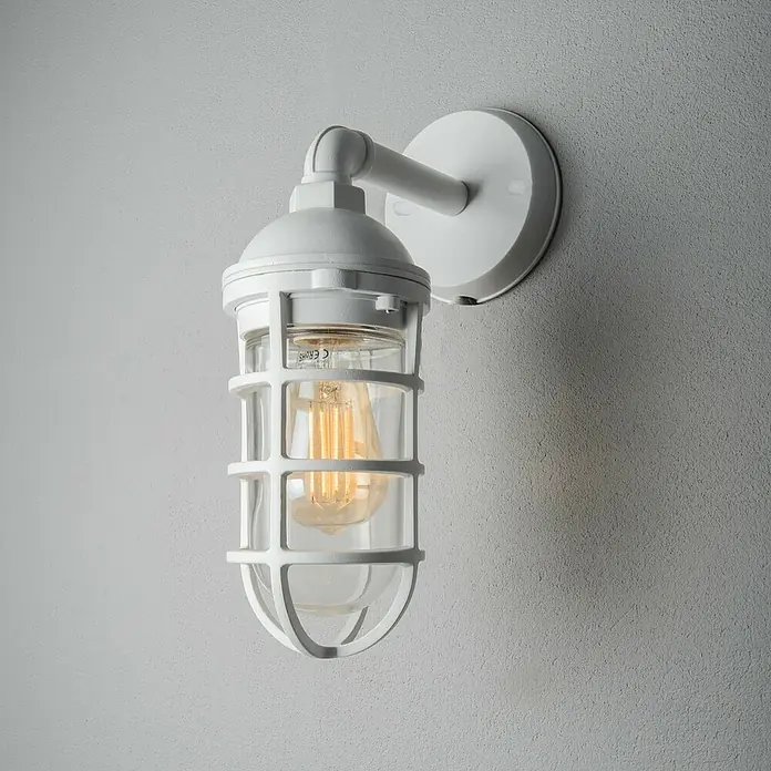 Konstsmide Außenwandleuchte Olbia - 20 W, Weiß, IP44 - Eine weiße Wandleuchte im industriellen Stil mit einem schützenden Käfig um das Leuchtmittel.