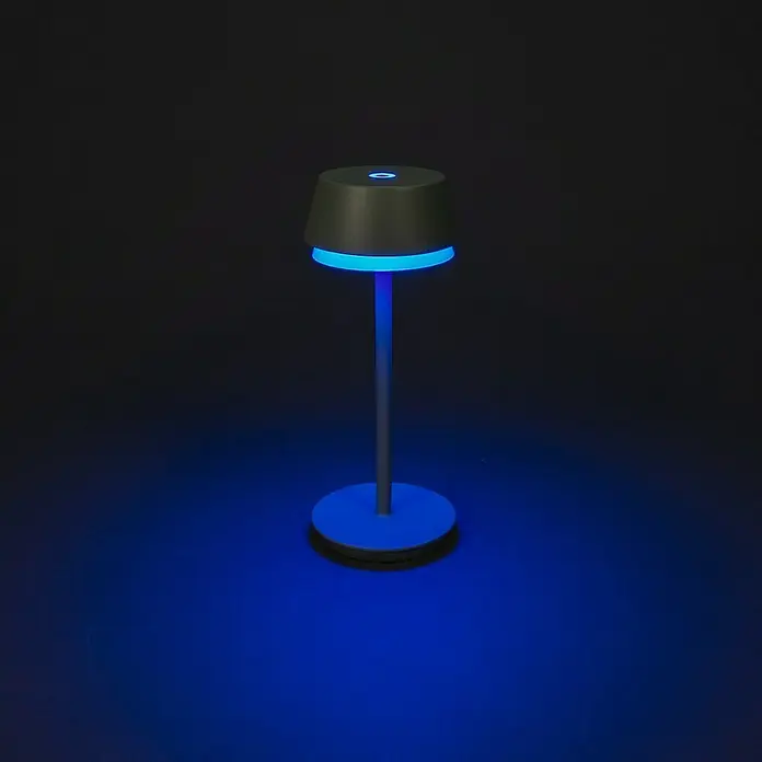 Konstsmide Akku-Tischleuchte Lyon - 2,5 W, L x B x H: 12 x 12 x 30 cm, Mintgrün, RGBW - Eine moderne Tischleuchte mit blauem Licht in einem dunklen Raum. Das Lichtdesign ist minimalistisch und elegant.