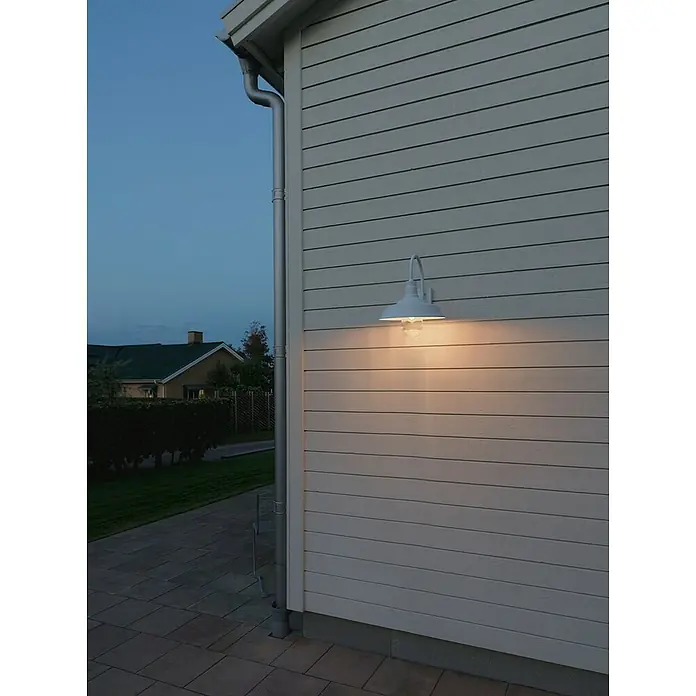 Konstsmide Außenwandleuchte Trapani - 20 W, Weiß, IP44 - Weiße Außenleuchte an einer Hauswand mit Holzverkleidung. Die Lampe strahlt warmes Licht und sorgt für eine gemütliche Atmosphäre.