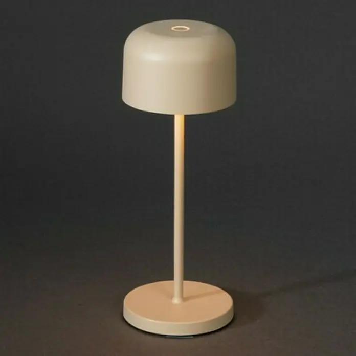 Konstsmide Akku-Tischleuchte Lille Mini - 2,5 W, L x B x H: 7,5 x 7,5 x 20 cm, Sand, Mehrfarbig - Nahaufnahme einer eleganten, beigen Tischleuchte mit einem runden Lampenschirm und einem schlanken Ständer.