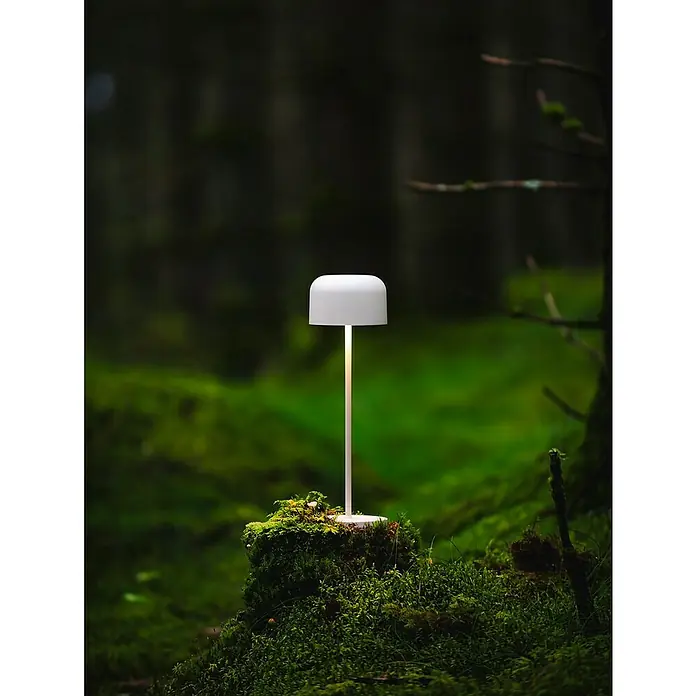 Konstsmide Akku-Tischleuchte Lille - 3,5 W, L x B x H: 11 x 11 x 36 cm, Weiß, Mehrfarbig - Elegante weiße Tischleuchte auf einem moosbewachsenen Baumstumpf im Wald. Die Lampe strahlt warmes Licht aus und setzt einen modernen Akzent in der Natur.