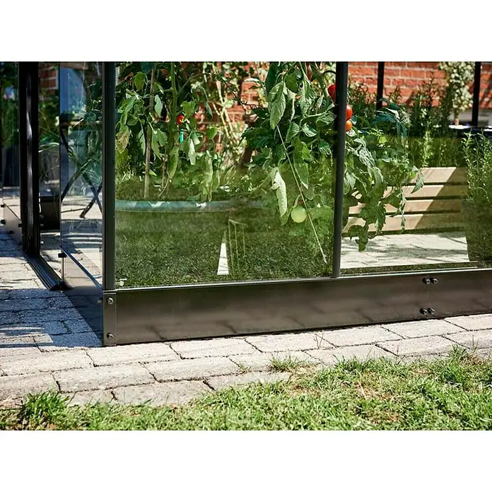 Halls Gewächshaus-Fundament - 189 cm x 189 cm x 0,12 m, Passend für: Halls Gewächshaus Qube 66 - Nahaufnahme eines Gewächshauses mit Tomatenpflanzen. Der Fokus liegt auf der soliden Konstruktion und dem satten Grün im Inneren.