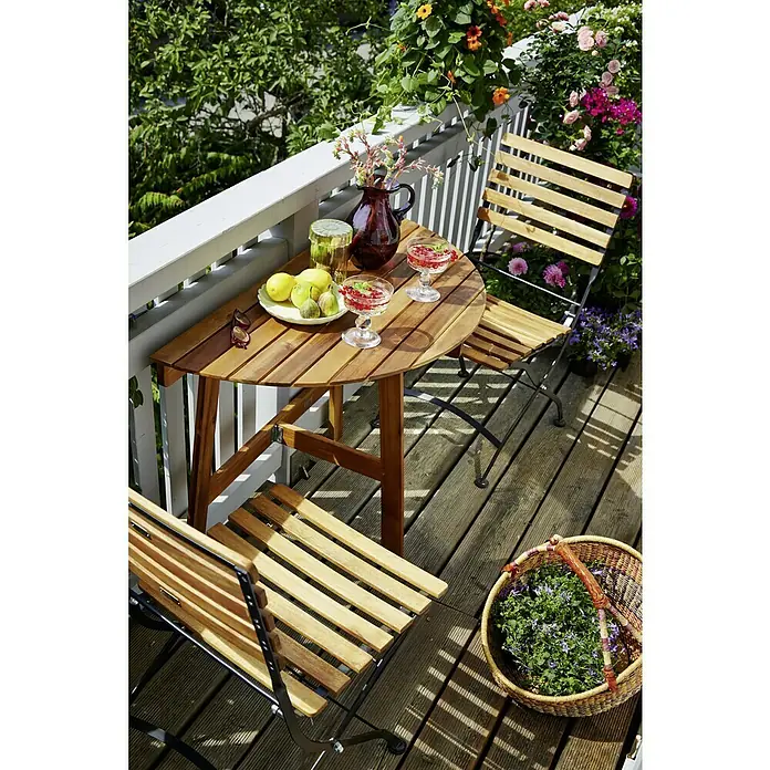Sunfun Balkonmöbel-Set Diana/Moni III - 3 -tlg., Akazie/Eukalyptus/Stahl, Naturbraun - Eine Nahaufnahme eines Balkons mit einem Holztisch, Stühlen, Blumen und Getränken.