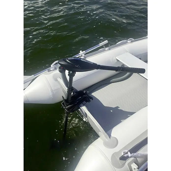 Hidea Motor fueraborda 2,5 HP - 1,8 kW, Control de timón, Eje corto - Primer plano de un bote inflable con un motor eléctrico Haswing montado. El motor es negro y se extiende hacia el agua.